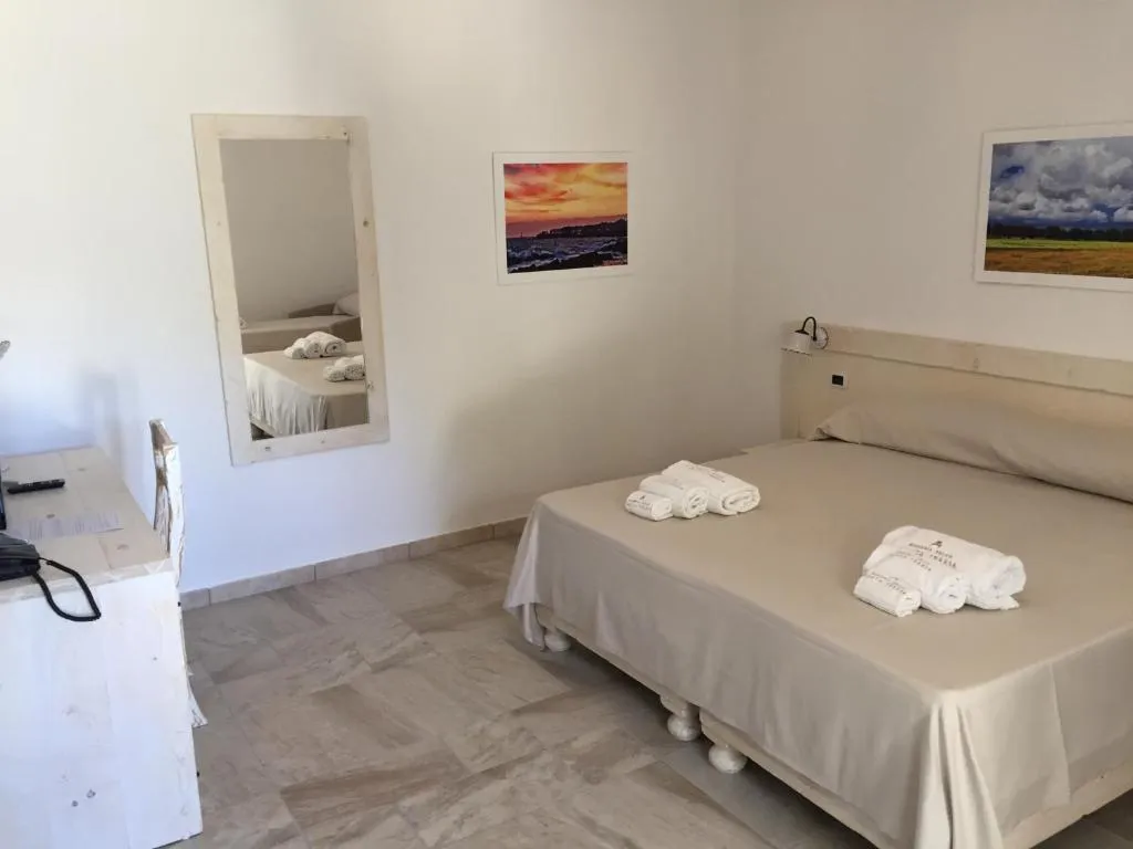 Camera luminosa con letto matrimoniale, specchio e foto paesaggistiche