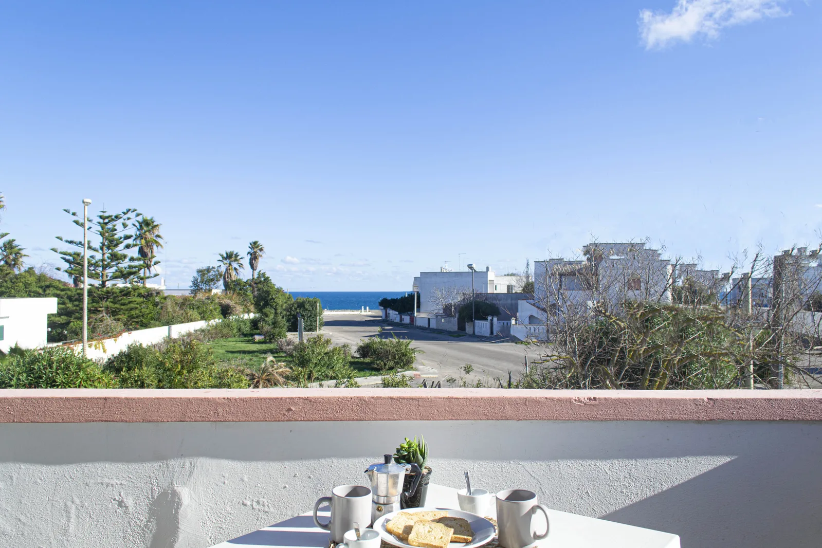 Colazione su tavolo in terrazza con vista sul mare e sulle palme