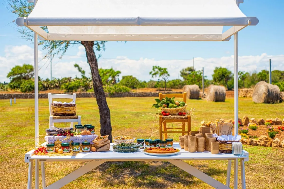 Banchetto di prodotti tipici locali all'aperto nella campagna pugliese