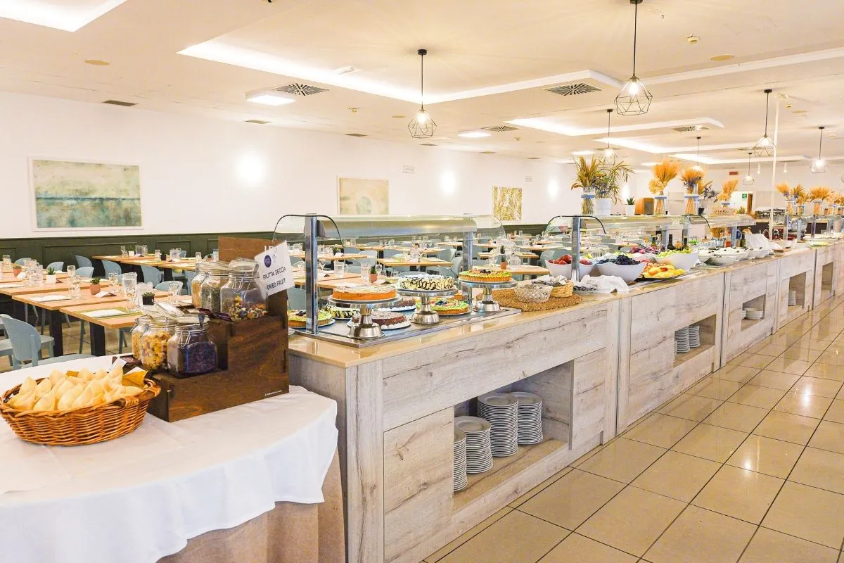 Buffet del ristorante con ampia varietà di dolci, frutta e piatti