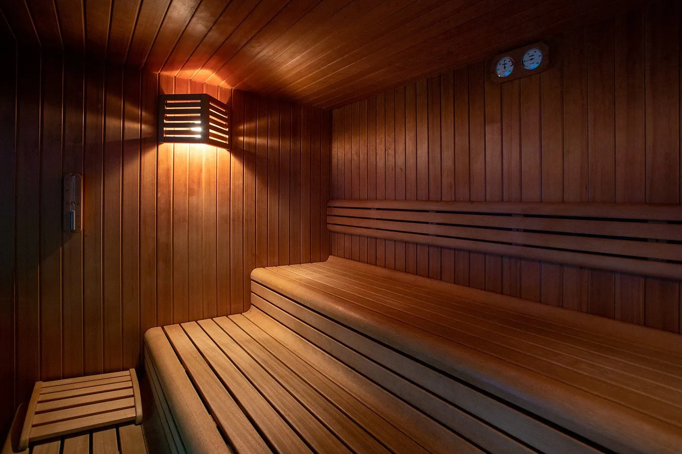 Sauna finlandese in legno con panche e illuminazione calda