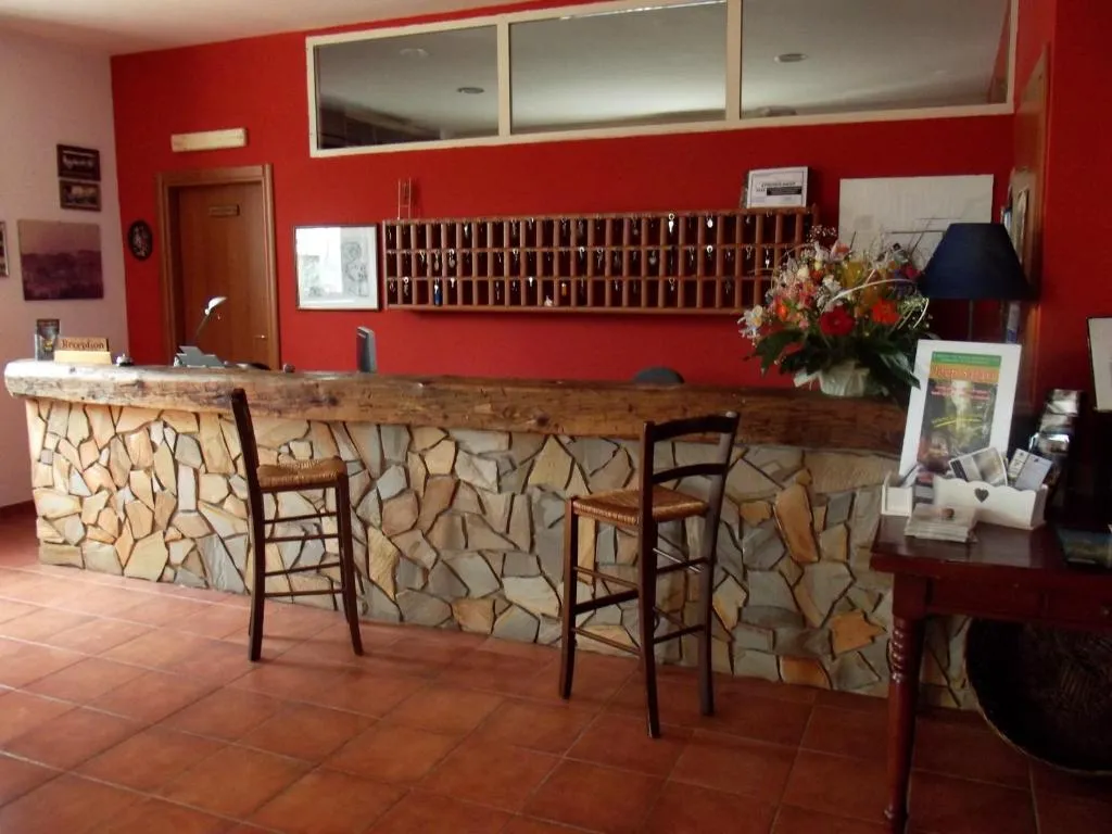 Reception dell'hotel con bancone in pietra e bacheca delle chiavi