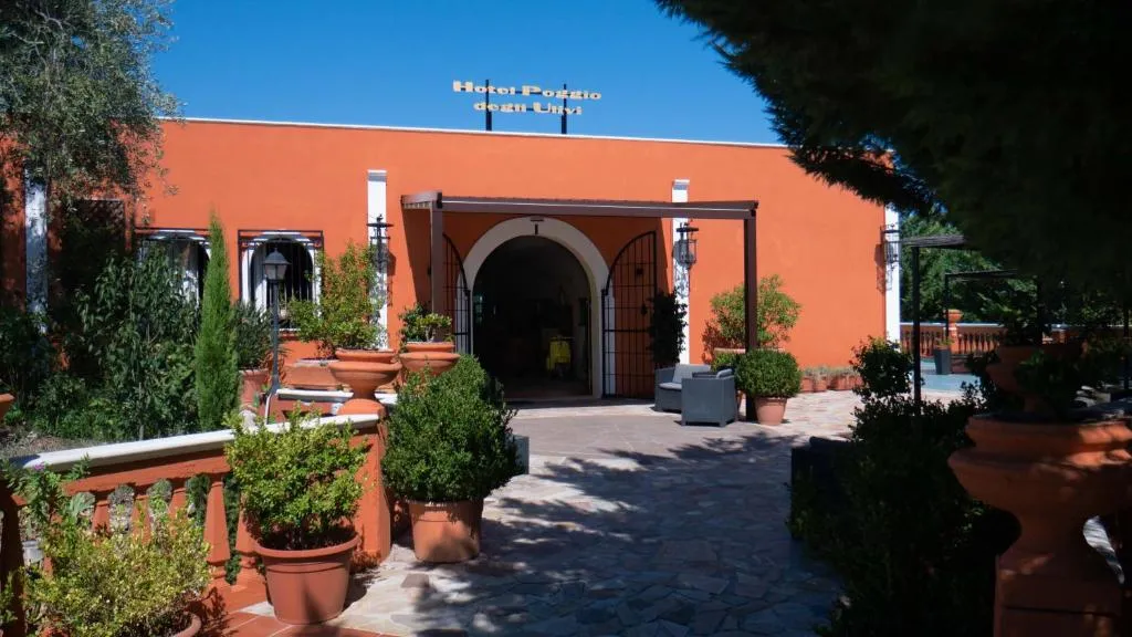 Ingresso dell'hotel con facciata arancione e piante in vaso