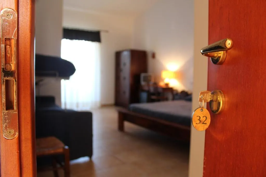 Porta della camera numero 32 aperta sulla stanza con letto