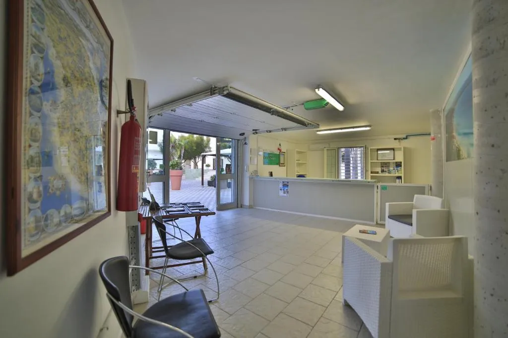 Interno della reception con bancone, mappa alle pareti e poltrone