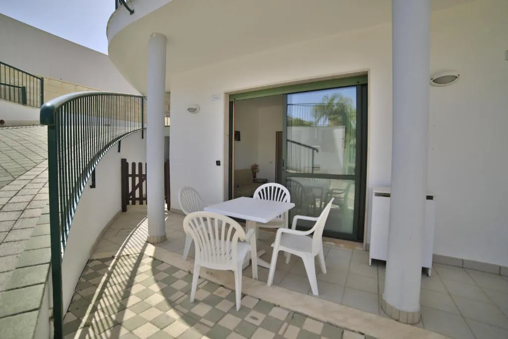 Terrazza privata con tavolo e sedie bianche e colonne