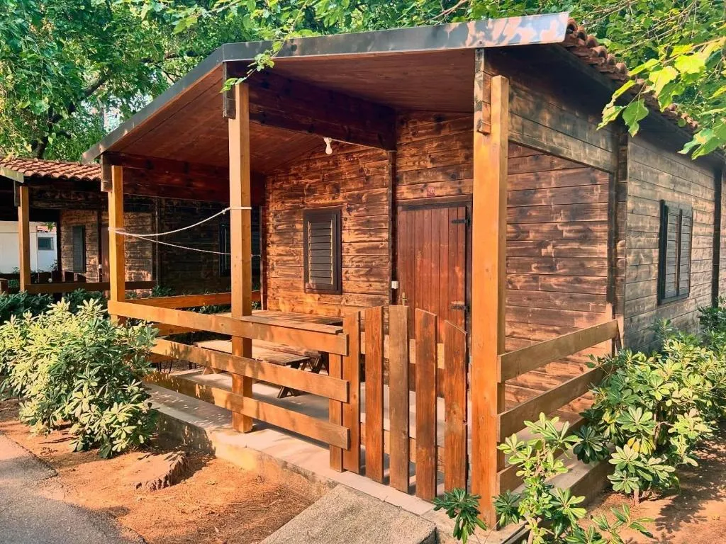 Bungalow in legno con veranda coperta immerso nel verde