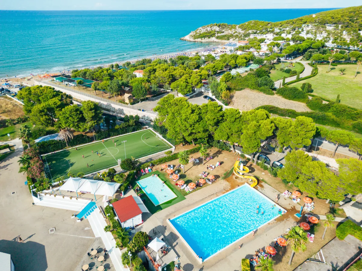 Vista aerea del villaggio con piscine, campo da calcio e spiaggia sul mare