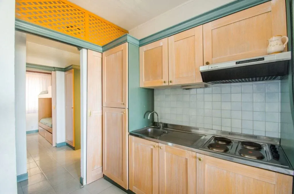 Angolo cucina con mobili in legno, piano cottura e camera sul retro