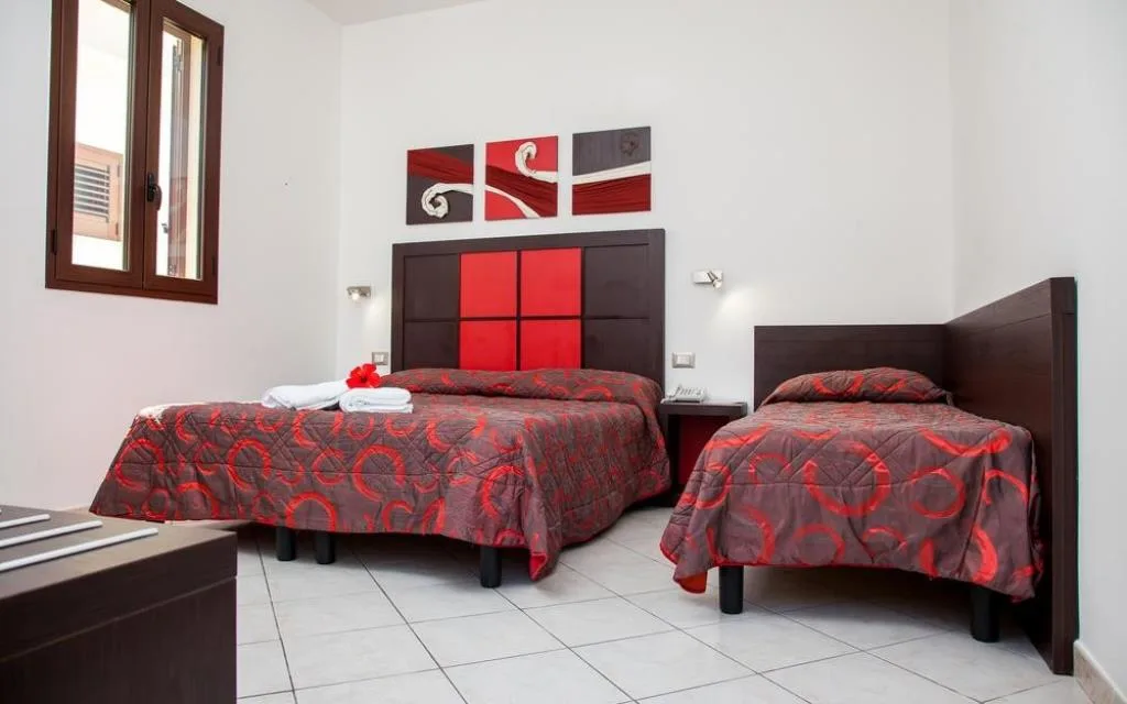 Camera tripla con letto matrimoniale e singolo, testiera rossa e nera e pavimento in piastrelle