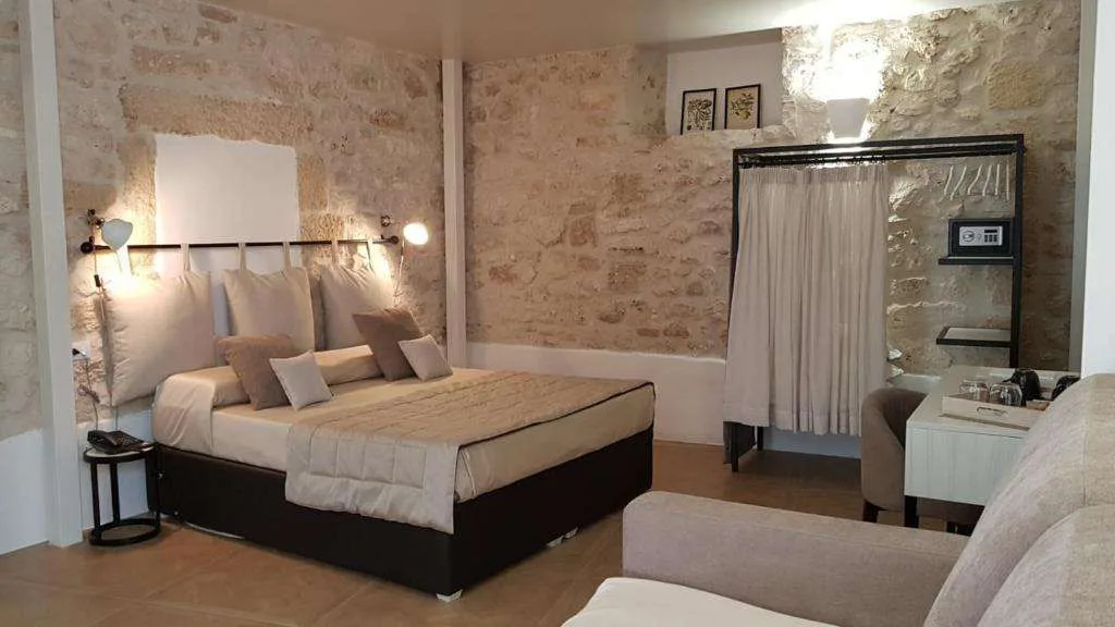 Camera con letto matrimoniale e pareti in pietra a vista