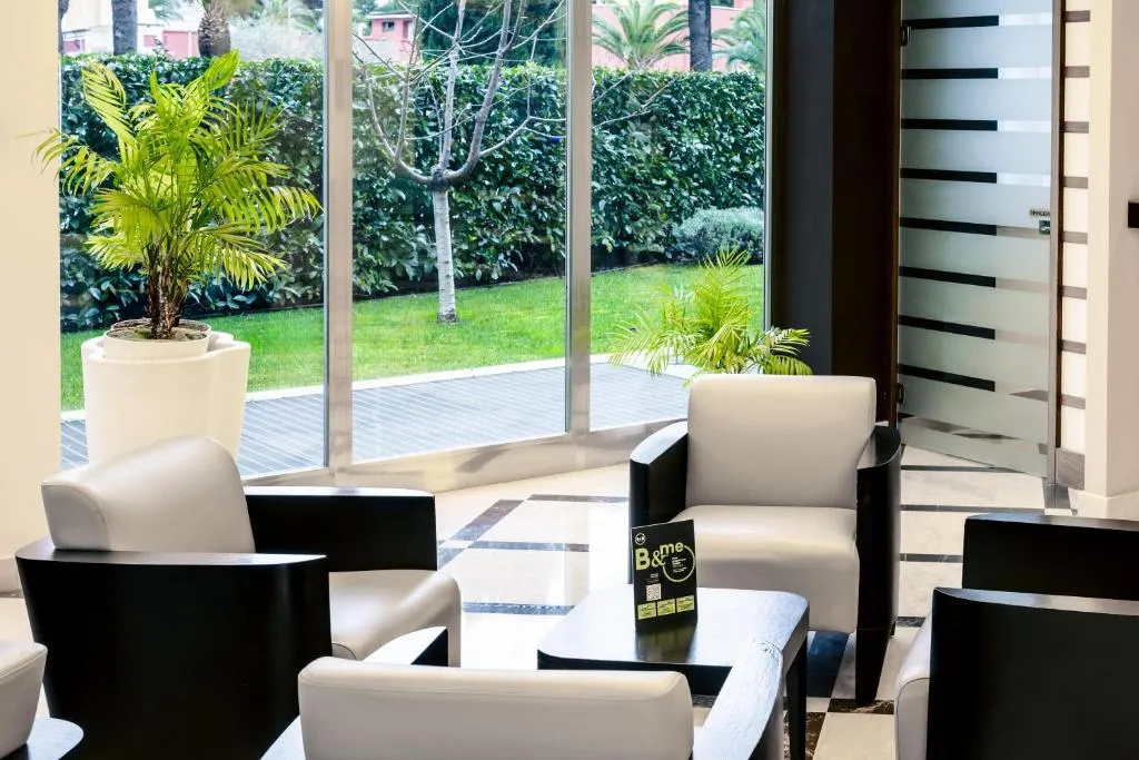 Salottino con poltrone bianche e vista sul giardino esterno