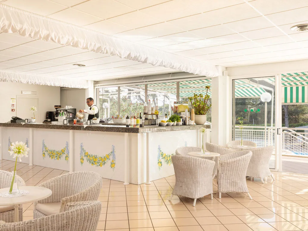 Bar interno con barista, sedie in vimini e decorazioni a tema limoni