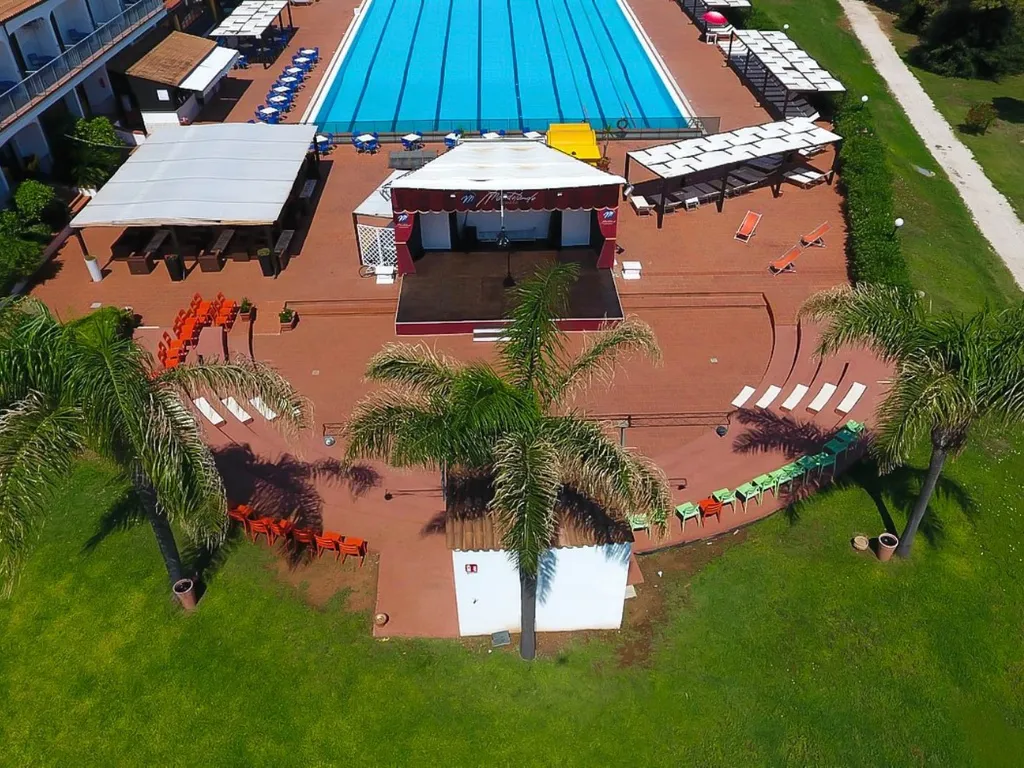 Veduta aerea della zona spettacoli con palco, palme e piscina