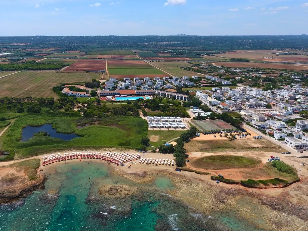 Vista aerea del villaggio turistico tra campagna e costa rocciosa