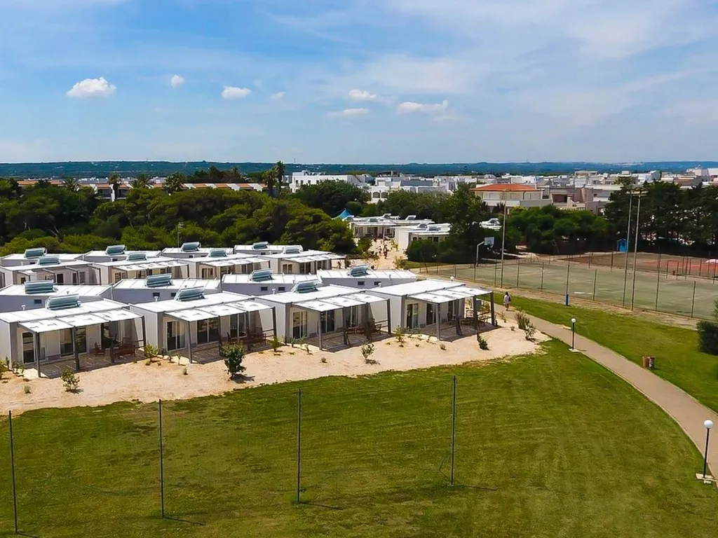 Veduta aerea dei bungalow moderni con campi sportivi nel villaggio