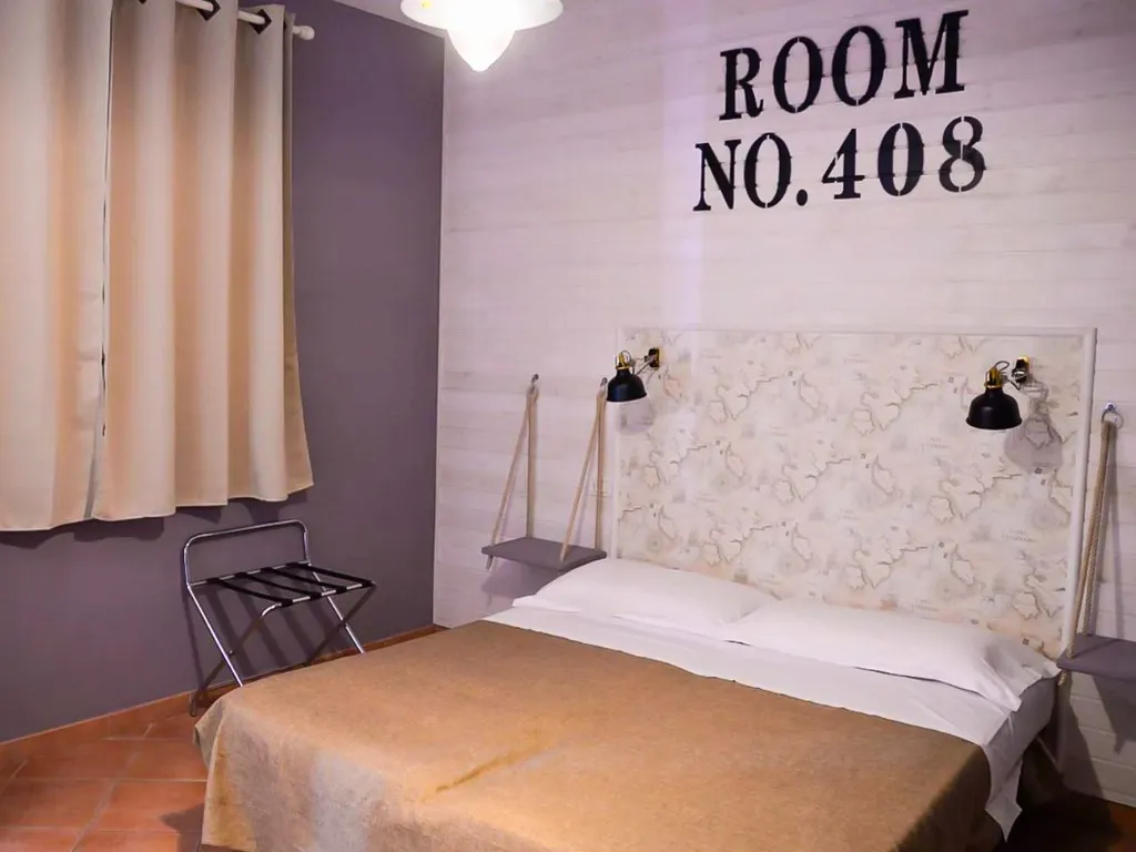 Camera con letto matrimoniale e testiera decorativa con mappa