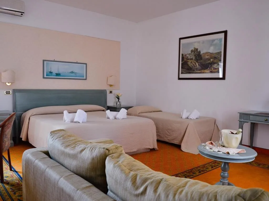 Camera con letto matrimoniale e singolo, divano e arredi in stile classico