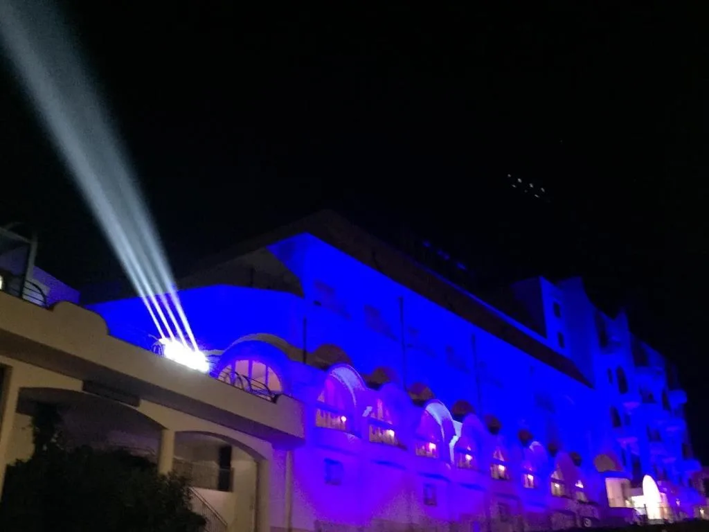 Facciata dell'hotel illuminata di blu con fascio di luce nella notte