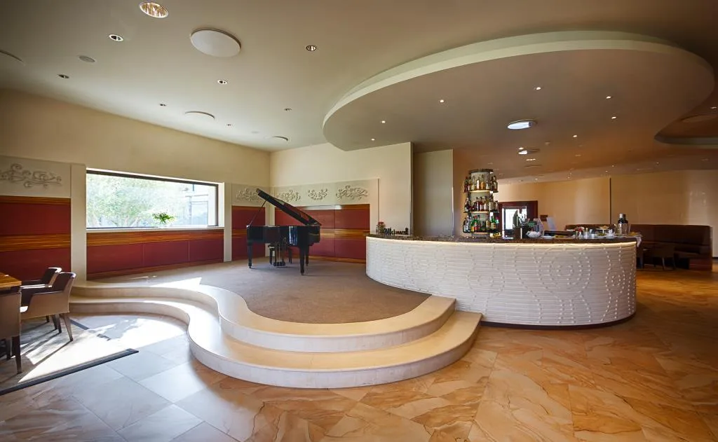Bar interno con pianoforte a coda e bancone curvo in pietra