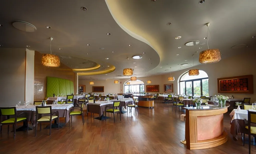 Ristorante moderno con pavimento in legno, illuminazione di design e tavoli eleganti