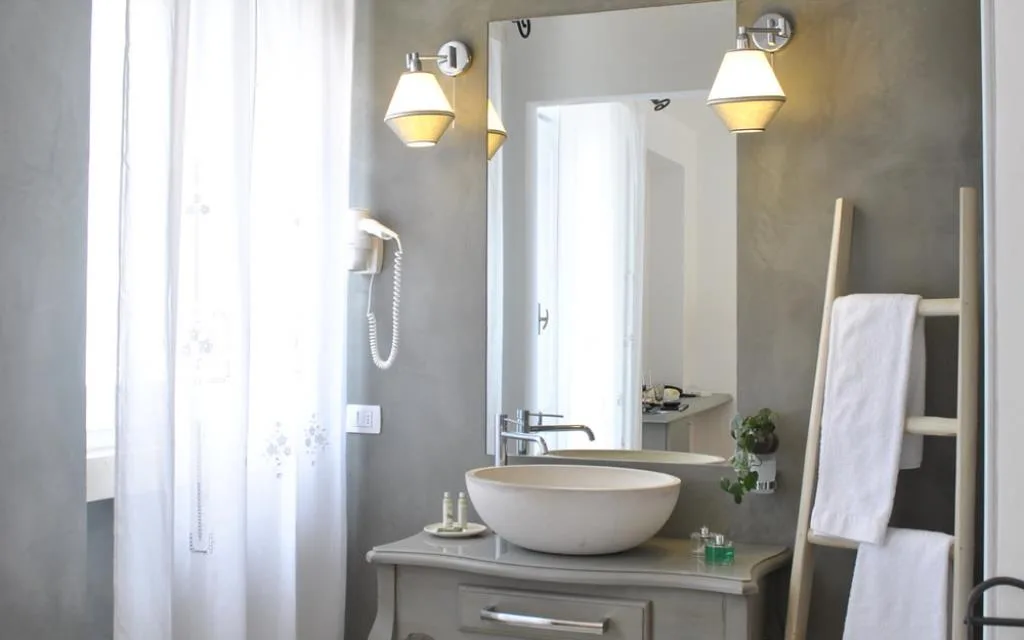 Bagno elegante con lavabo tondo, specchio e mobile in stile provenzale