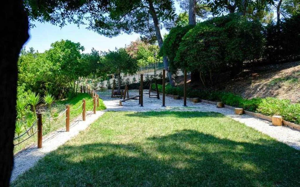 Giardino con prato verde, vialetti e area attrezzata all'aperto