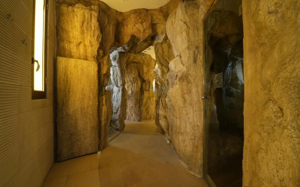 Corridoio tematico con pareti che imitano la roccia e illuminazione soffusa