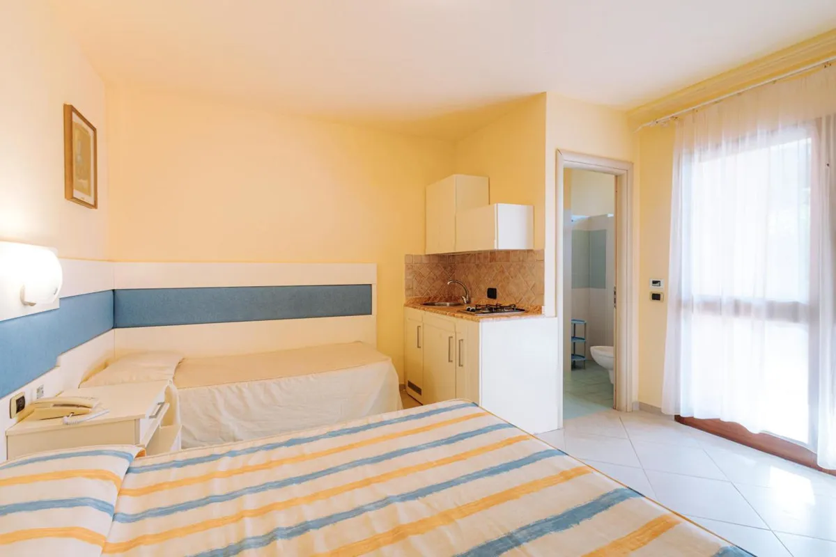 Camera con letto matrimoniale e singolo, angolo cottura e bagno