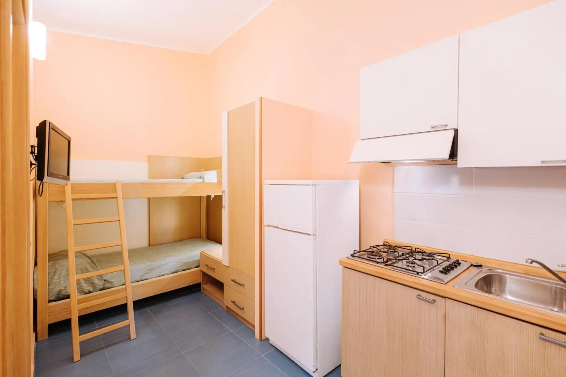 Monolocale con letto a castello, angolo cottura attrezzato e frigorifero
