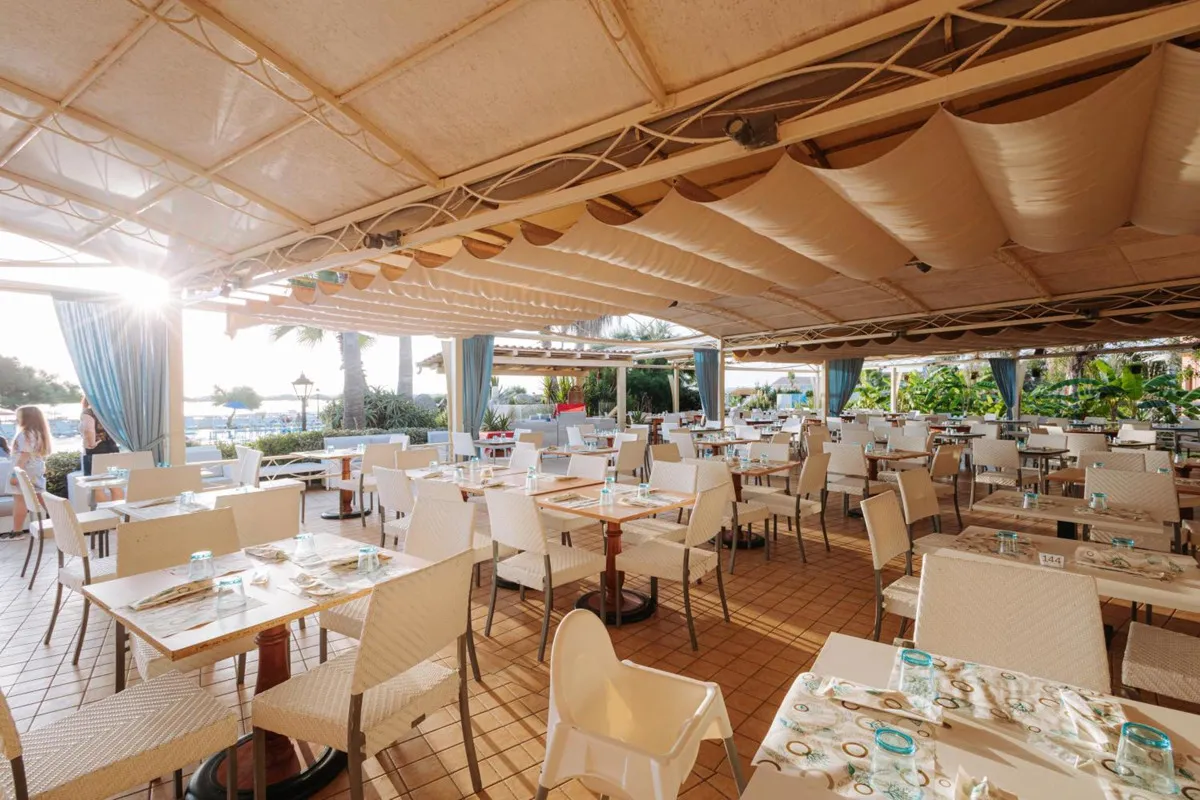 Ristorante all'aperto del resort con tavoli apparecchiati e copertura in tela