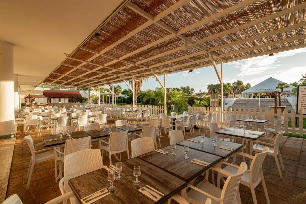 Ristorante all'aperto con tavoli in legno e pergolato in canniccio