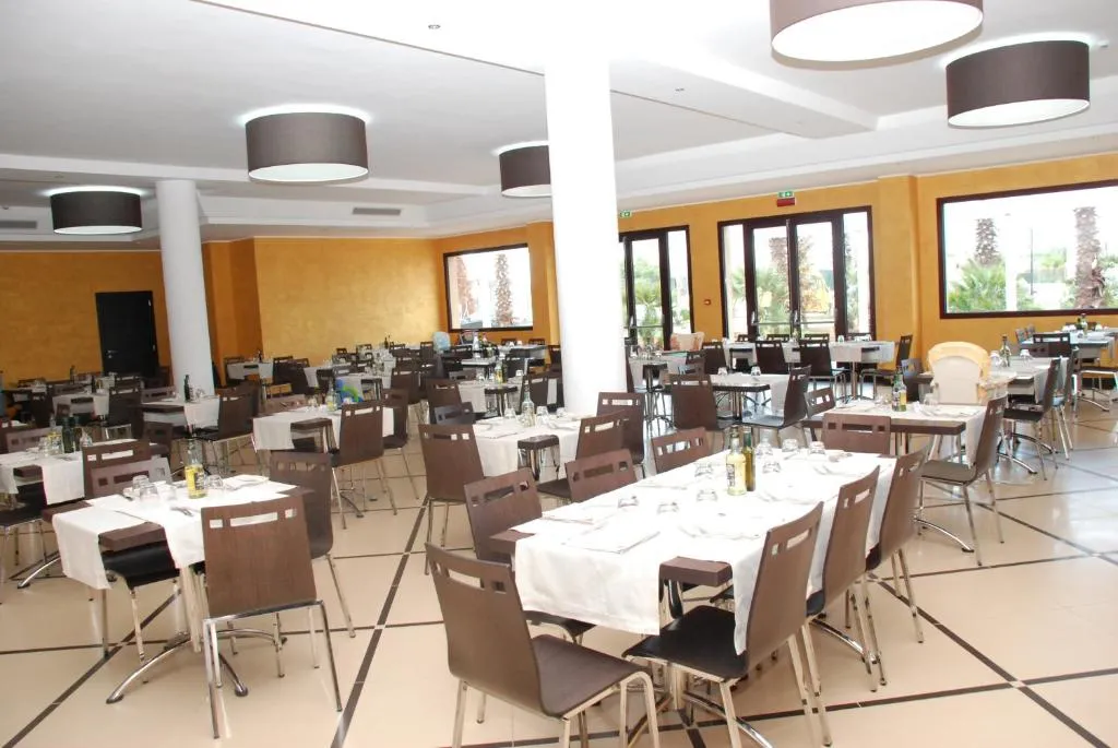 Sala ristorante interna con tavoli apparecchiati e sedie marroni