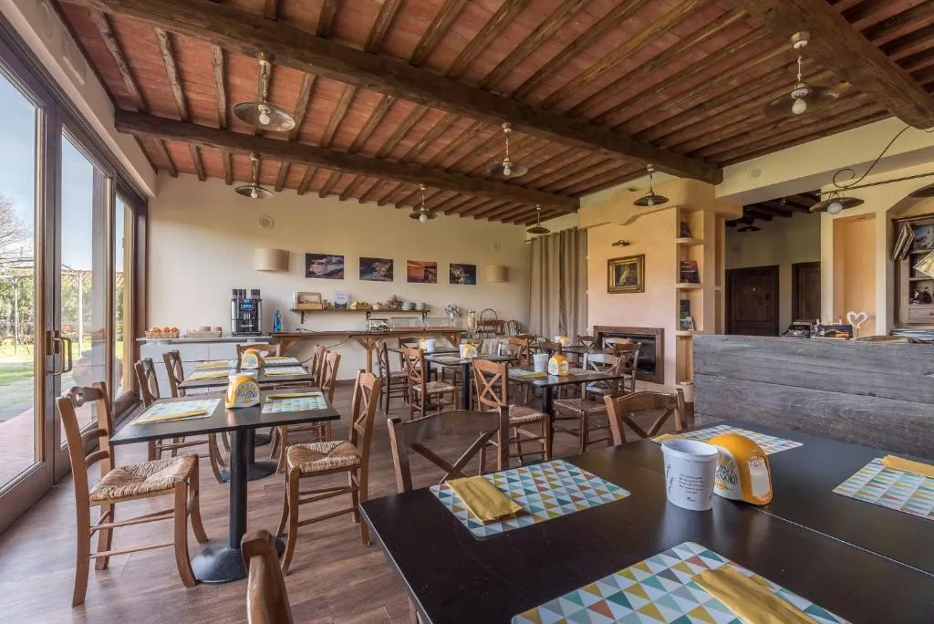 Sala colazione rustica con travi in legno, tavoli e angolo buffet