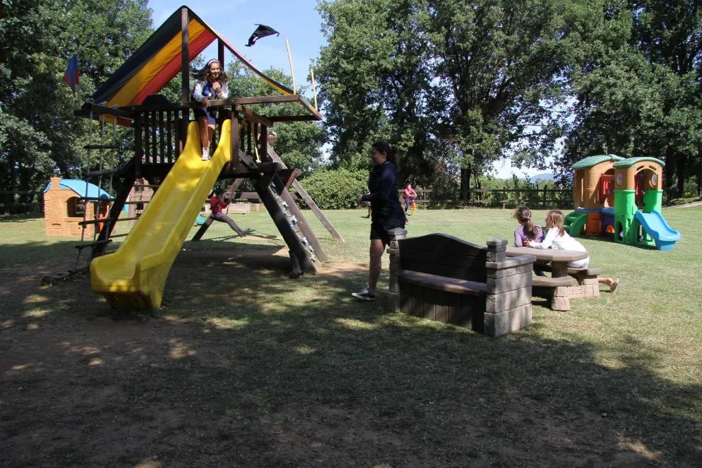 Bambini che giocano nell'area giochi all'aperto con scivolo