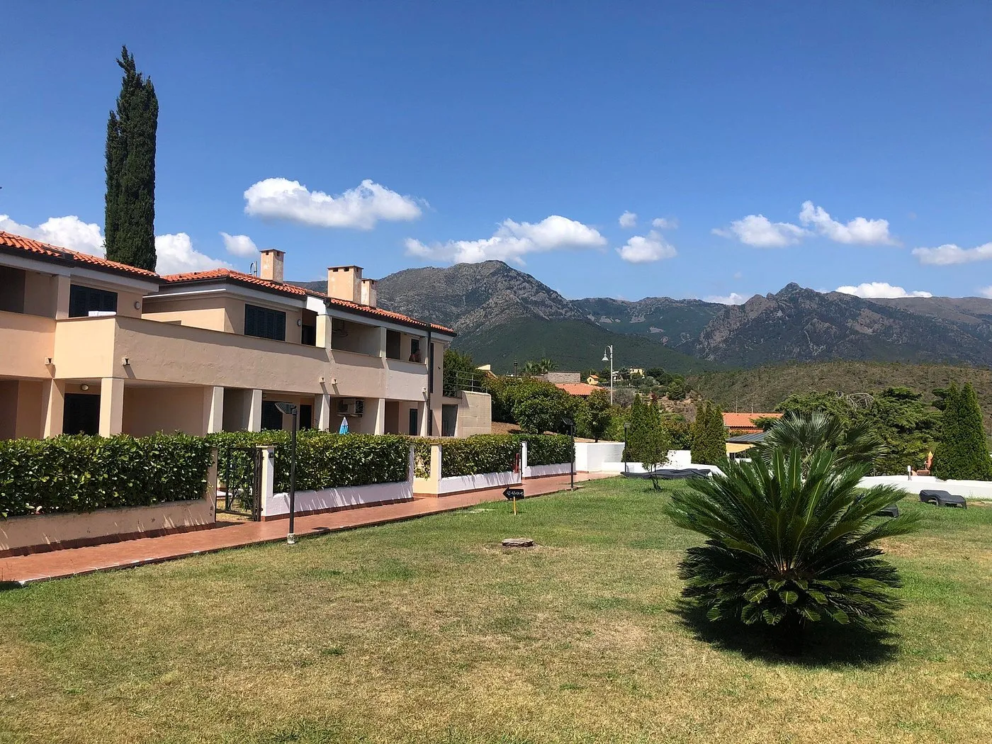 Edifici del residence con giardino e vista sulle montagne