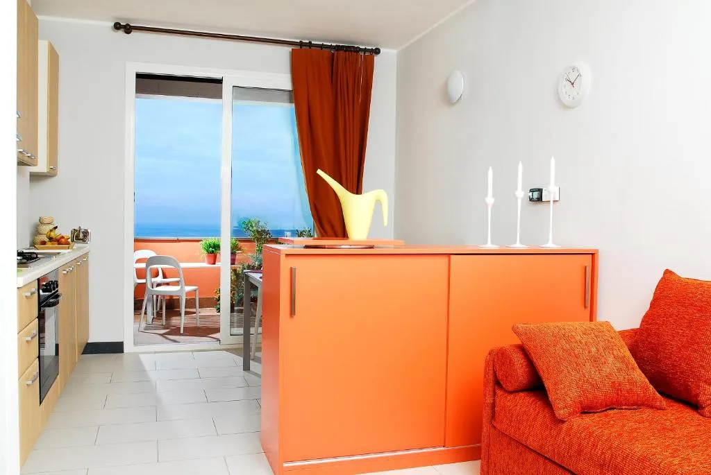 Soggiorno con mobile arancione, divano e terrazza con vista mare