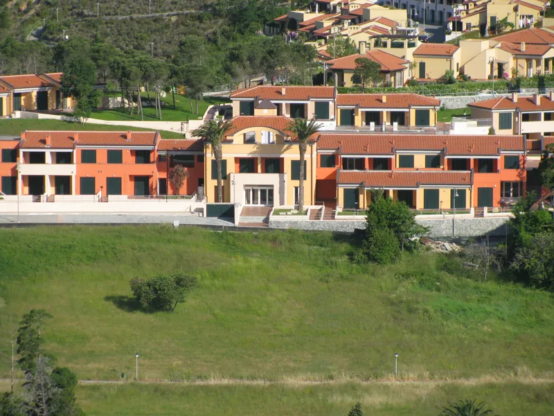 Edifici del residence color arancione su collina circondati dal verde