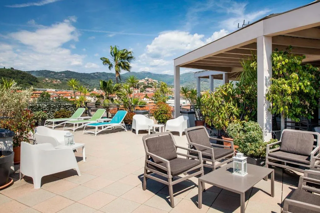 Solarium sul tetto con lettini, poltrone e vista panoramica sulle colline