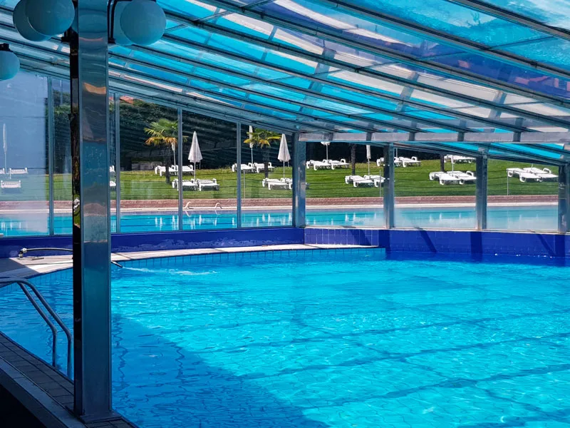 Piscina interna con copertura in vetro e vista sul giardino