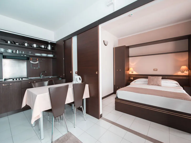 Monolocale con cucina e zona notte arredata in tonalità scure
