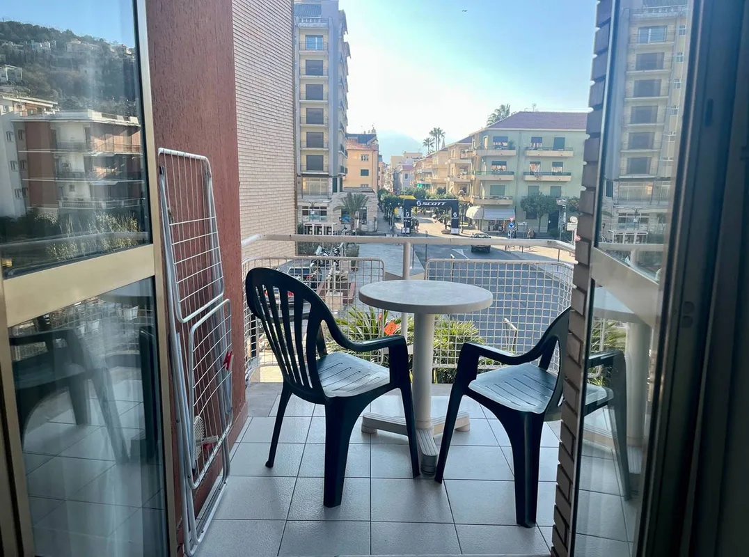 Balcone con tavolino e sedie e vista sulla strada e gli edifici circostanti