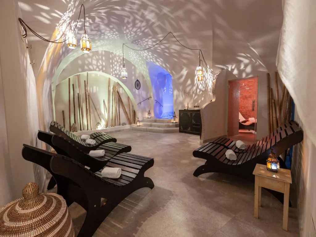 Zona relax spa con lettini in legno, lanterne marocchine e ambiente arabeggiante