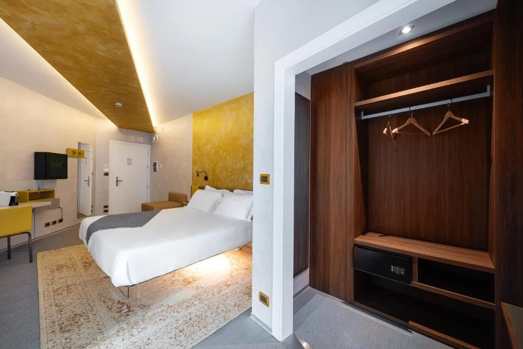 Camera matrimoniale con soffitto dorato, scrivania, armadio in legno e tappeto