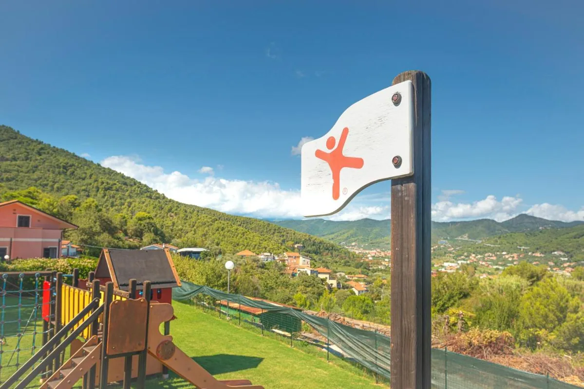 Insegna del parco giochi con vista panoramica su colline e paese