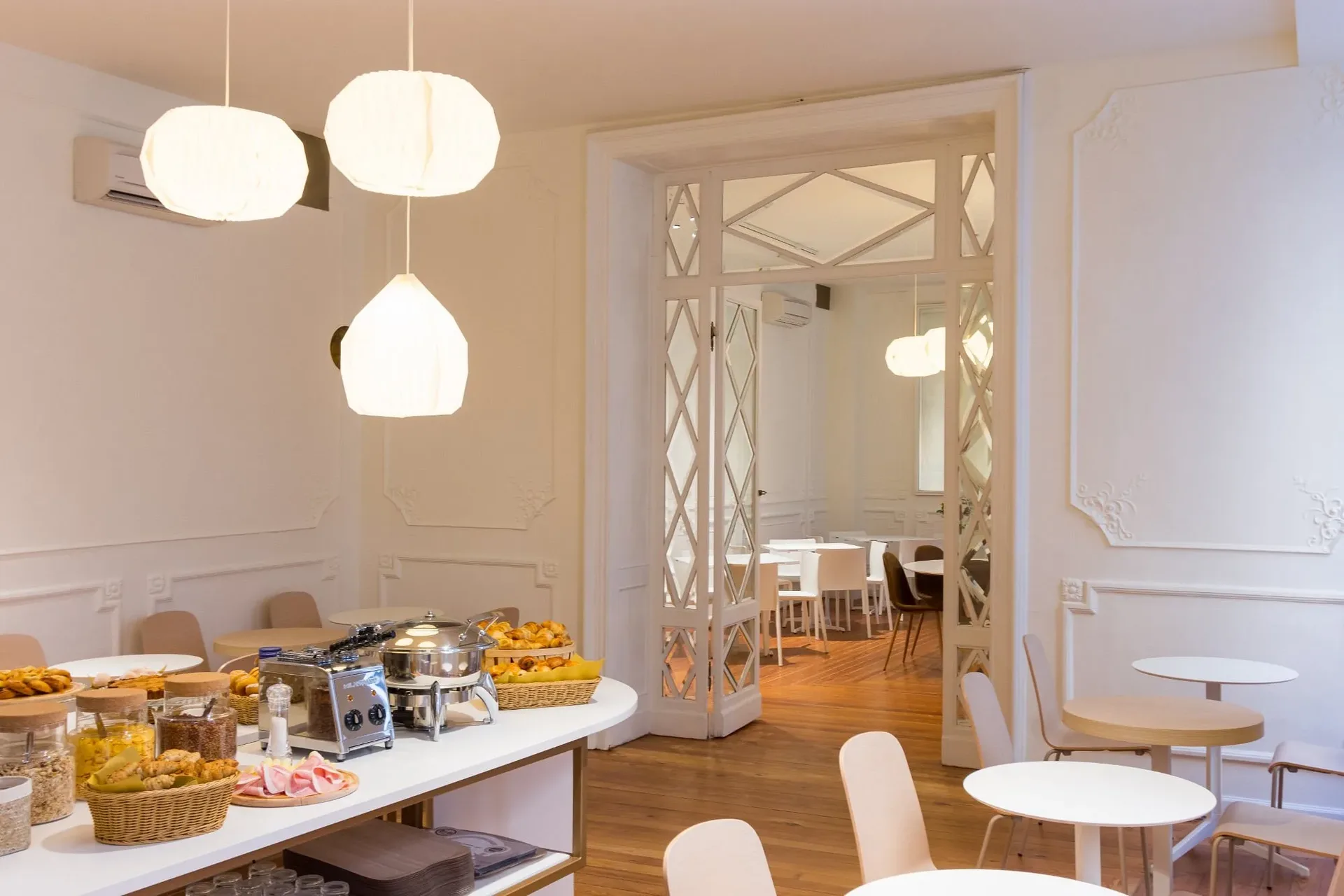 Area buffet della colazione con prodotti dolci e salati e arredo elegante bianco