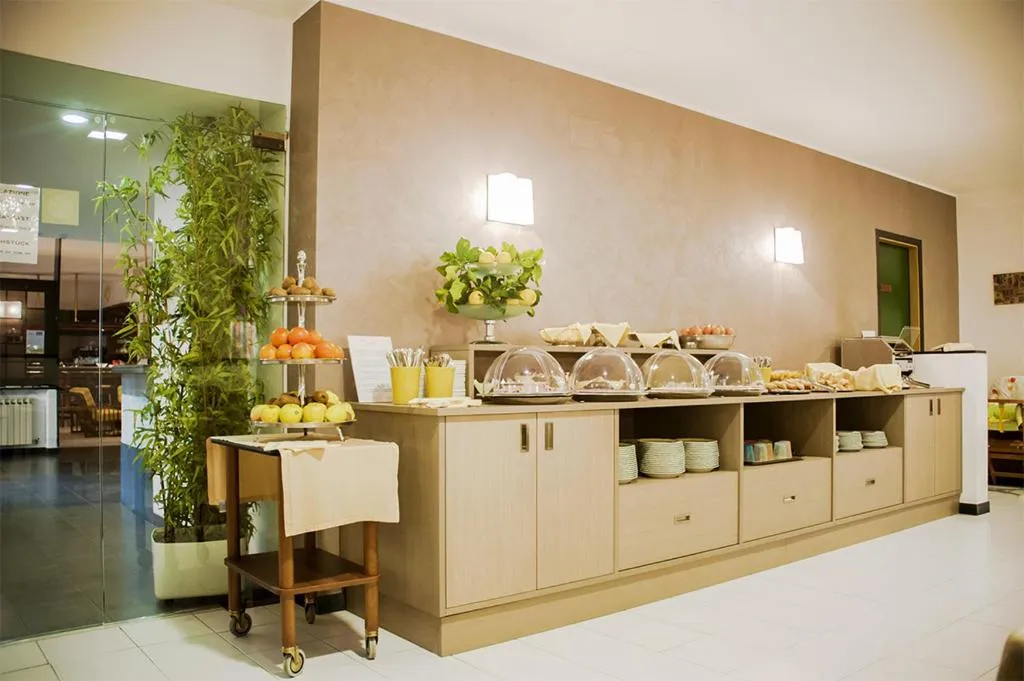 Buffet della colazione con frutta fresca, cupole per dolci e stoviglie
