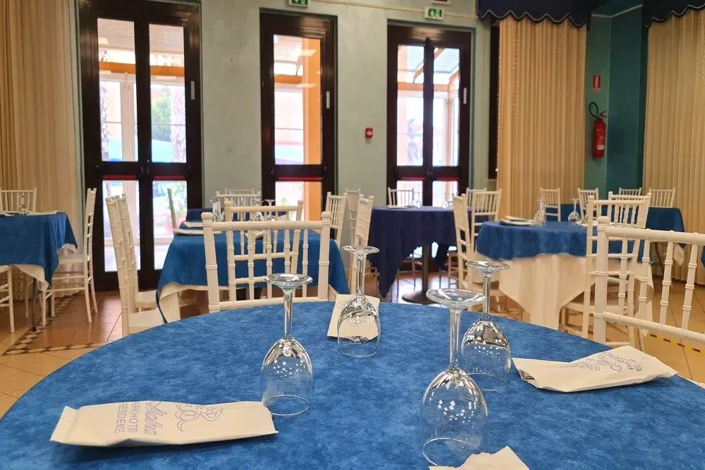 Dettaglio dei tavoli del ristorante con tovaglie blu e bicchieri
