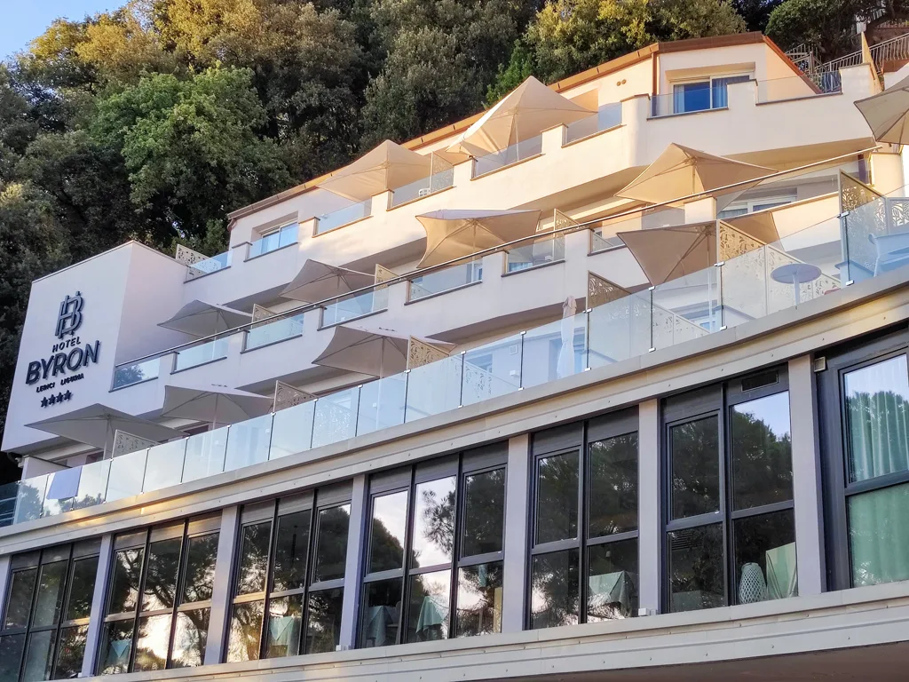 Facciata esterna dell'Hotel Byron a Lerici con balconi, ombrelloni e insegna