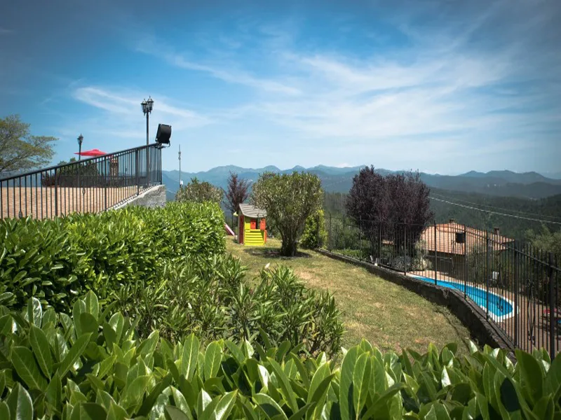 Giardino verde con vista sulle colline e piscina sullo sfondo